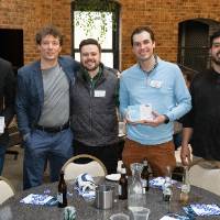 Group of 7 event attendees standing together and smiling for photo